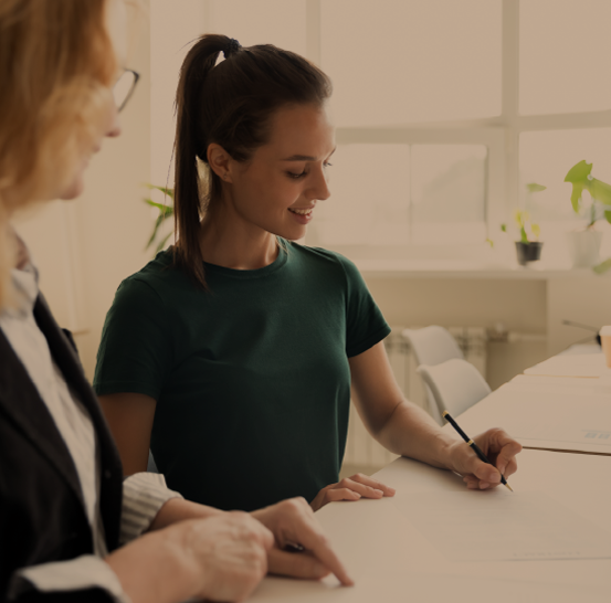 Older woman helping a teen fill out paperwork