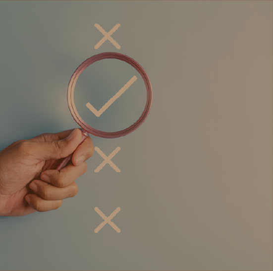 Hand holding up a magnifying glass over options. One option is a check mark while the others show x's