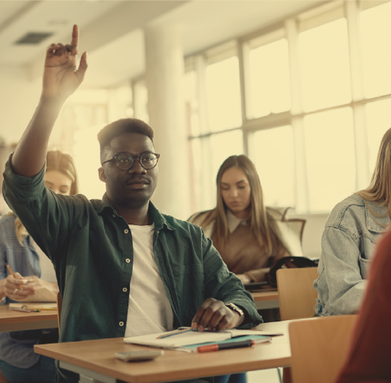 Student raising his arm to answer speak while in a classroom